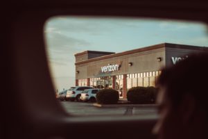 cars parked in front of Verizon during daytime