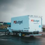 a blue and white budget truck parked in a parking lot