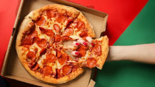 Fresh pizza being pulled from the box after using papa johns first responder discount