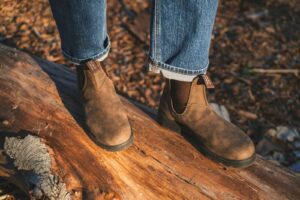 person in blue denim jeans and blundstone leather boots