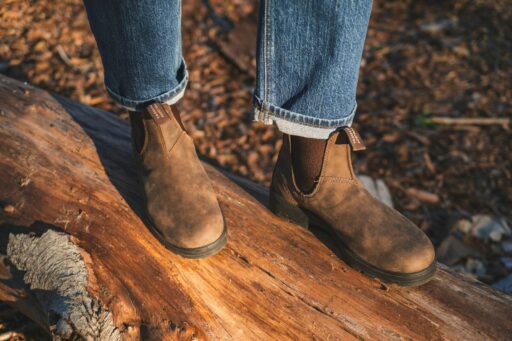 person in blue denim jeans and blundstone leather boots
