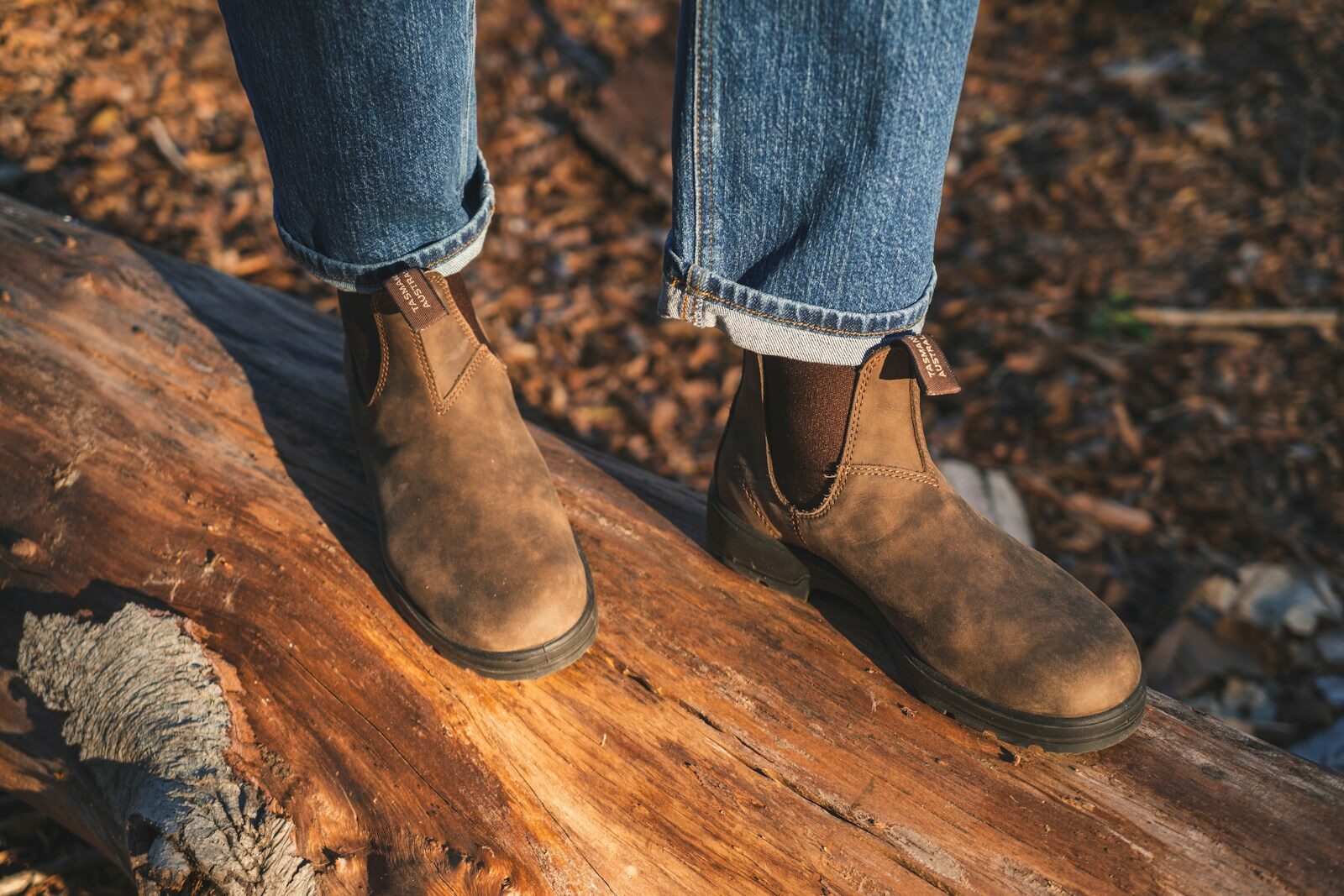 person in blue denim jeans and blundstone leather boots