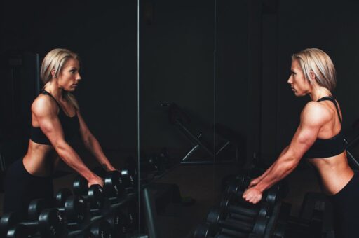 woman in equinox fitness club gym looking in mirror