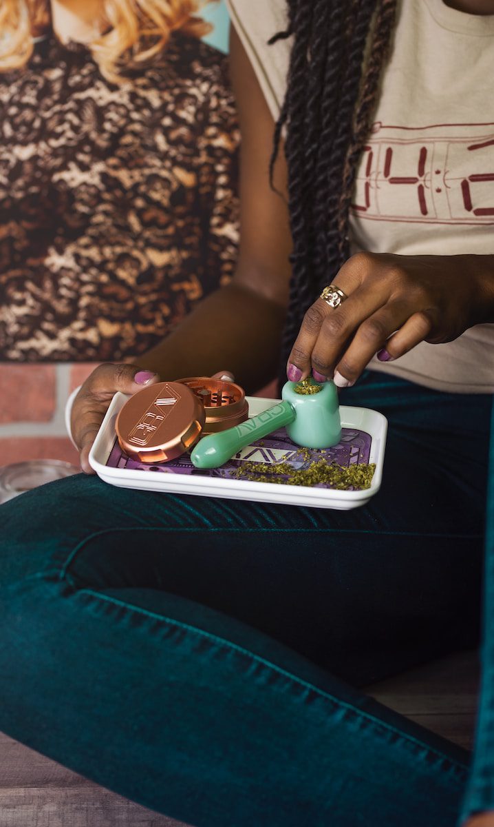 person preparing trulieve spoon pipe while sitting