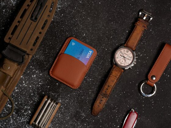 a watch, wallet, and other leather goods on a table