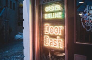 brown cash wooden back door with red and yellow neon sign