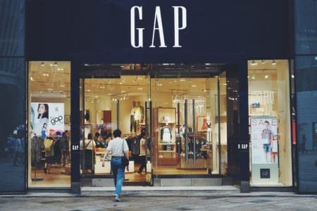 person in white shirt and blue jeans walking inside GAP store earning cash back